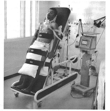 Figura 01: Paciente submetido ao ortostatismo passivo por meio da prancha ortostática. Fonte: (SARMENTO, 2009)