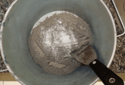 Clínquer e gesso sendo homogeneizados manualmente