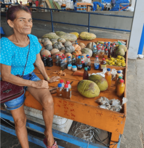 Ex-comunitária deste projeto de extensão em sua banca de plantas medicinais e preparados fitomedicamentos caseiros na Feira Municipal de Coari – AM