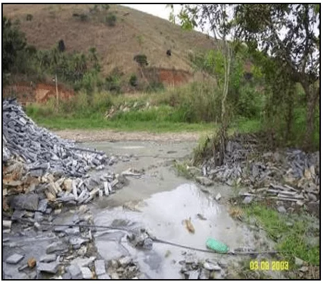 Situação do córrego após lançamento inadequado de resíduos de rochas ornamentais. Fonte: OLIVEIRA (2009).
