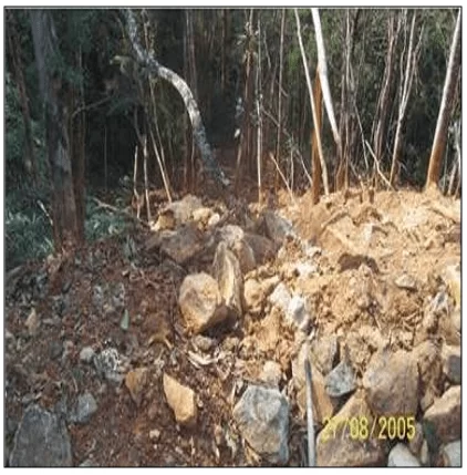 Bota-fora de uma lavra de esteatito destruindo a mata ciliar de uma nascente na Mata dos Magros, Ouro Preto/MG. Fonte: ALMEIDA (2006).