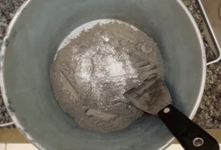 Clínquer e gesso sendo homogeneizados manualmente